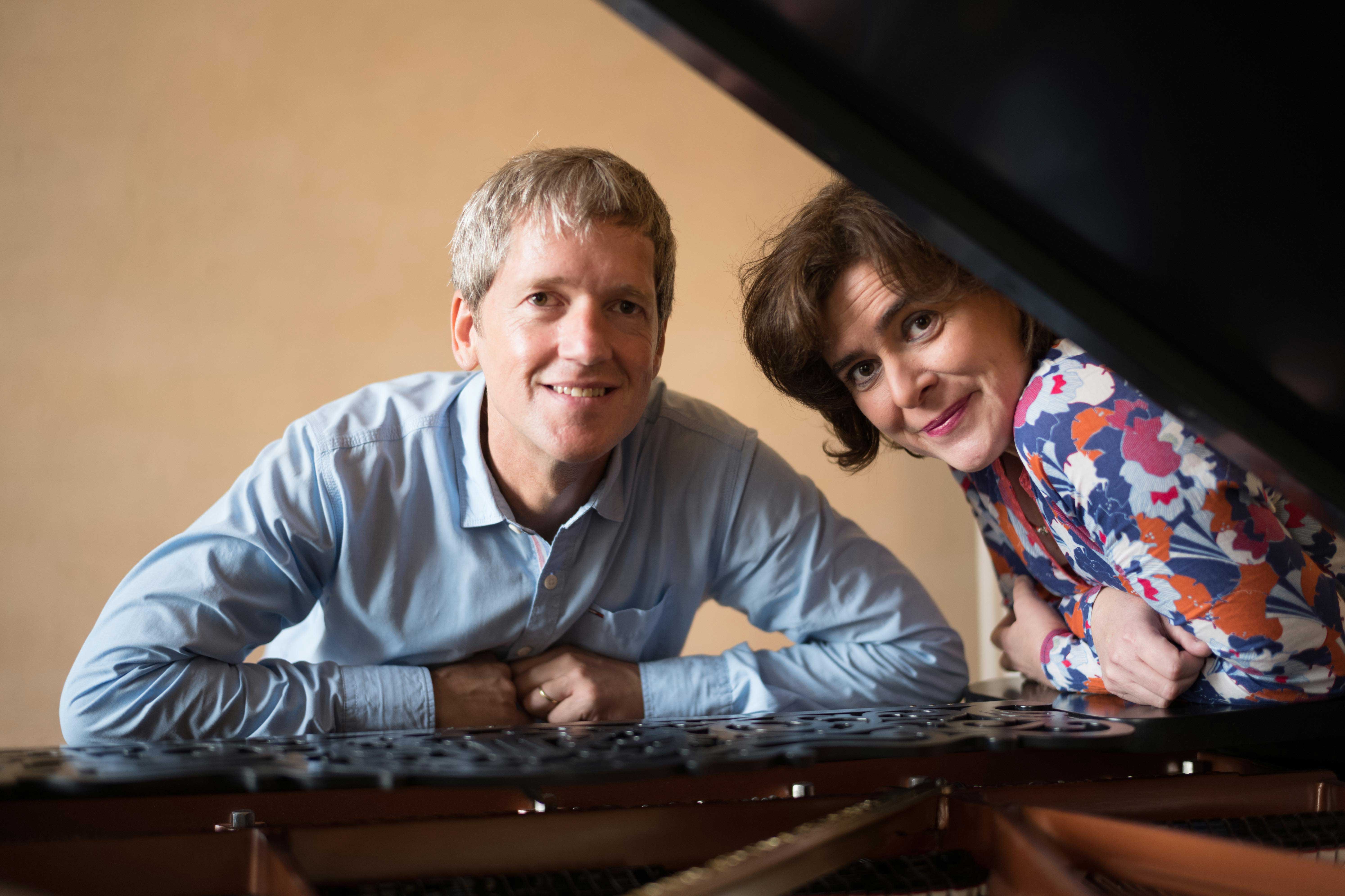 Musikerpaar posiert am Flügel. 