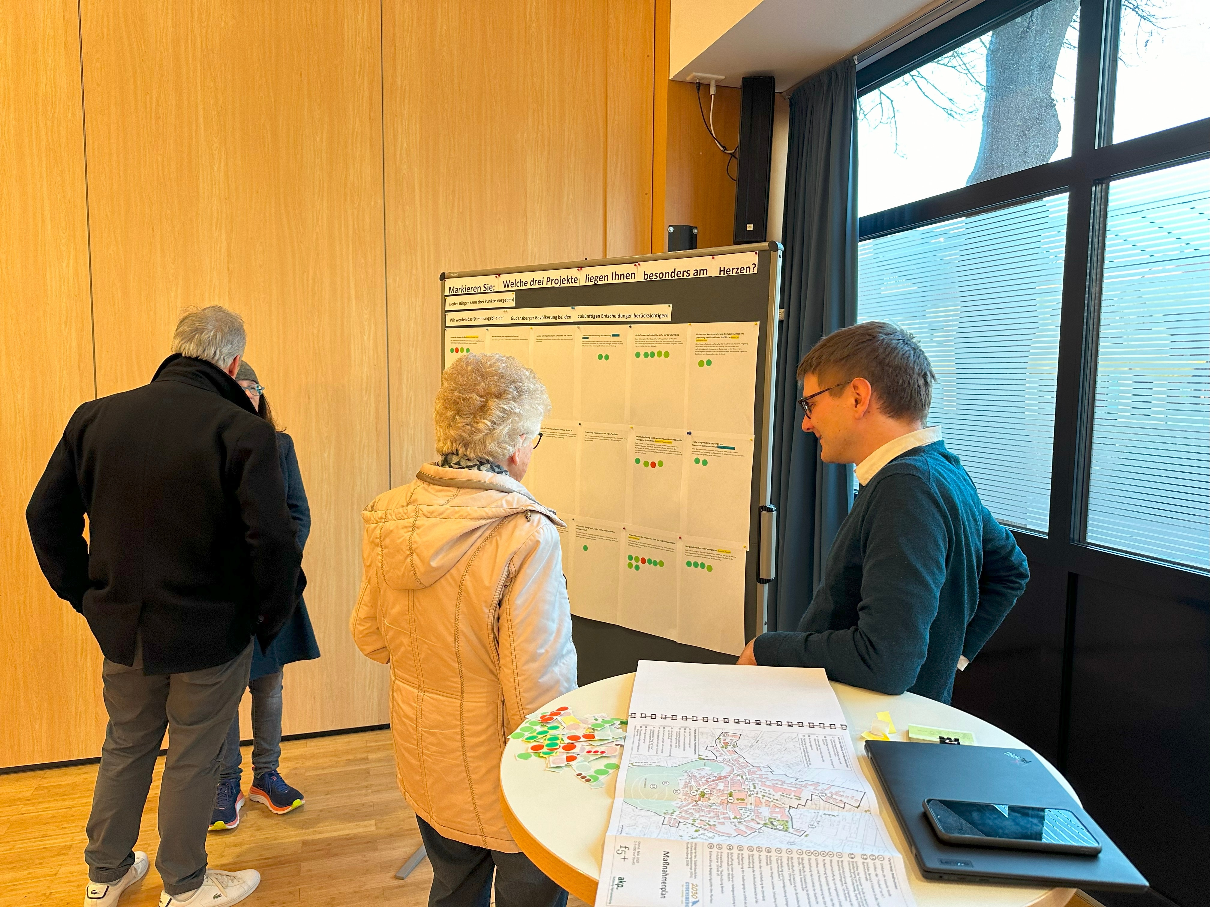 4 Personen stehen vor einer Pinnwand.