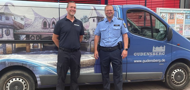 zwei Männer vor Auto mit Gudensberg Logo