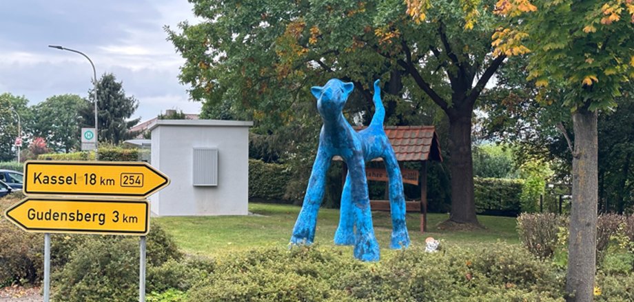 Skulptur blaue Katze auf einer Wiese an einer Straße