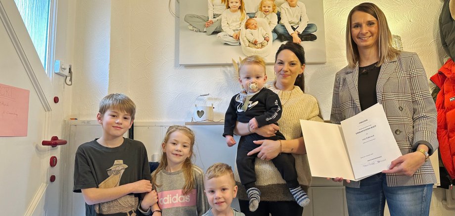 Familie und Bürgermeisterin vor Familienbild
