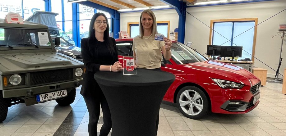 Zwei Frauen stehen an einem Stehtisch in einem Autohaus
