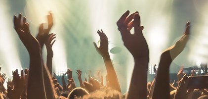 Feiernde Menschen vor eine Bühne