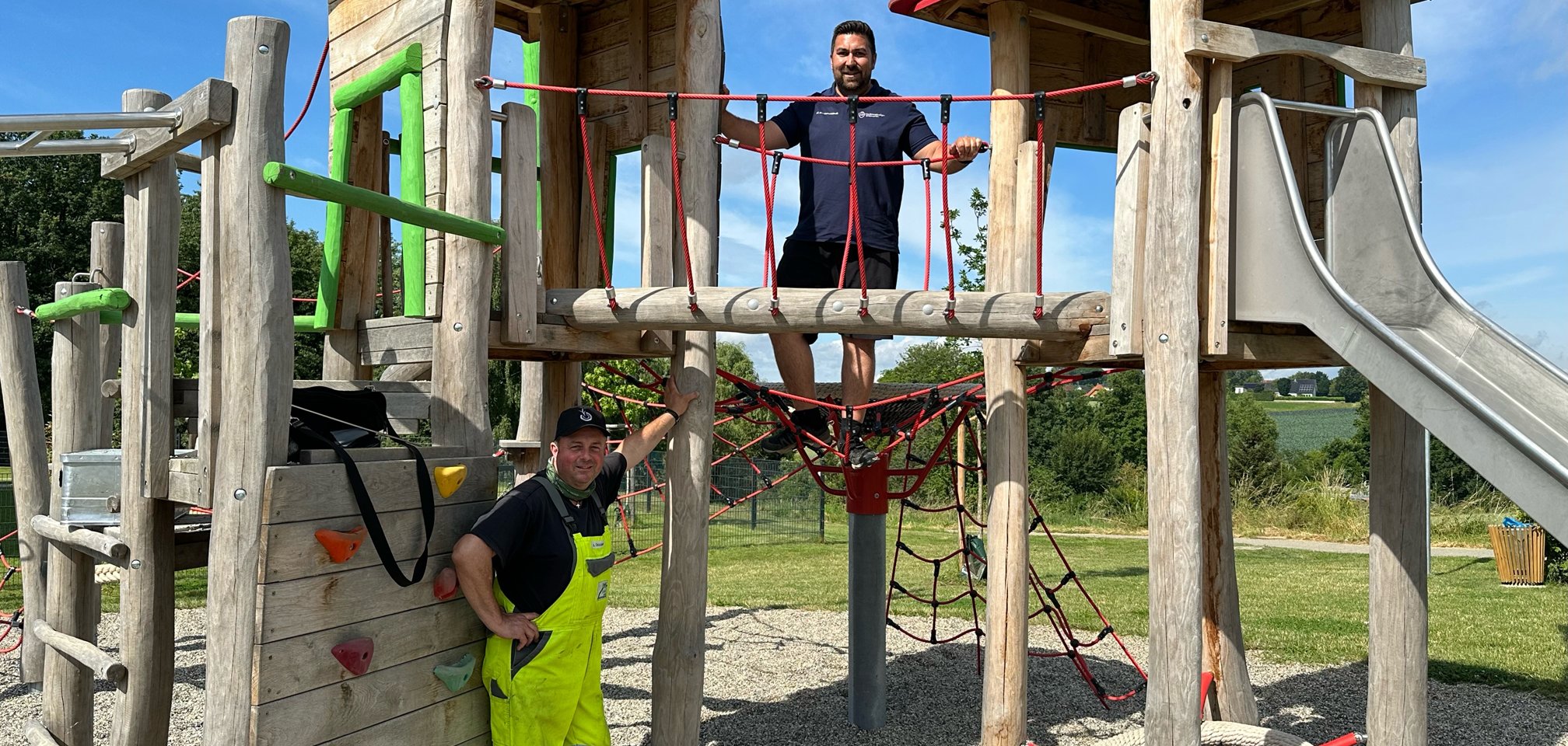 Spielplatzprüfer auf und Bauhofsmitarbeiter an Spielgerät