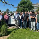 Menschengruppe bei Übergabe vor Elektrobus