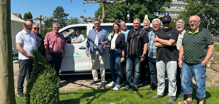 Menschengruppe bei Übergabe vor Elektrobus