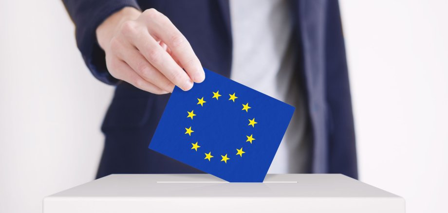 Voting. Man putting a ballot with European Union flag into a voting box.