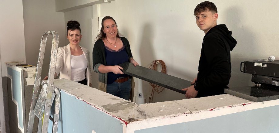 zwei Frauen und ein Junge beim Arbeiten im Jubengclub