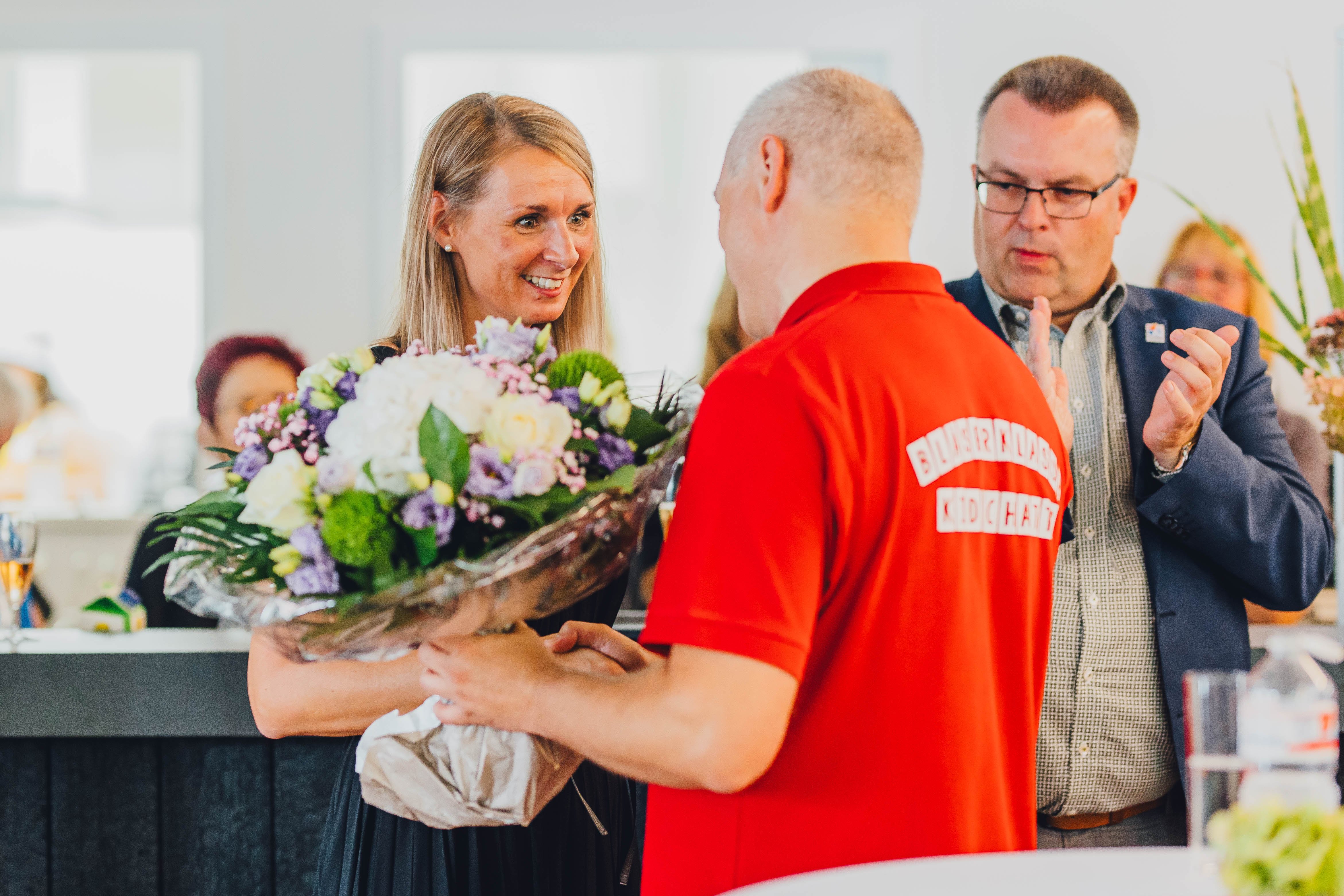 Mann überreicht Frau einen Blumenstrauß.