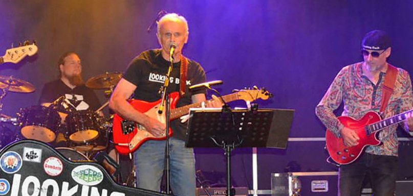 Band mit Gitarrenkoffer mit dem Titel Looking Back auf der Bühne