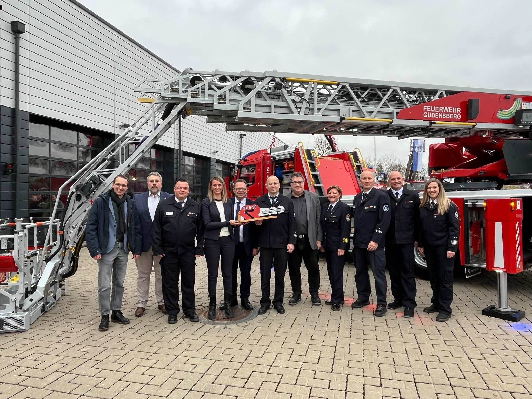 Männer und Frauen vor Drehleiter