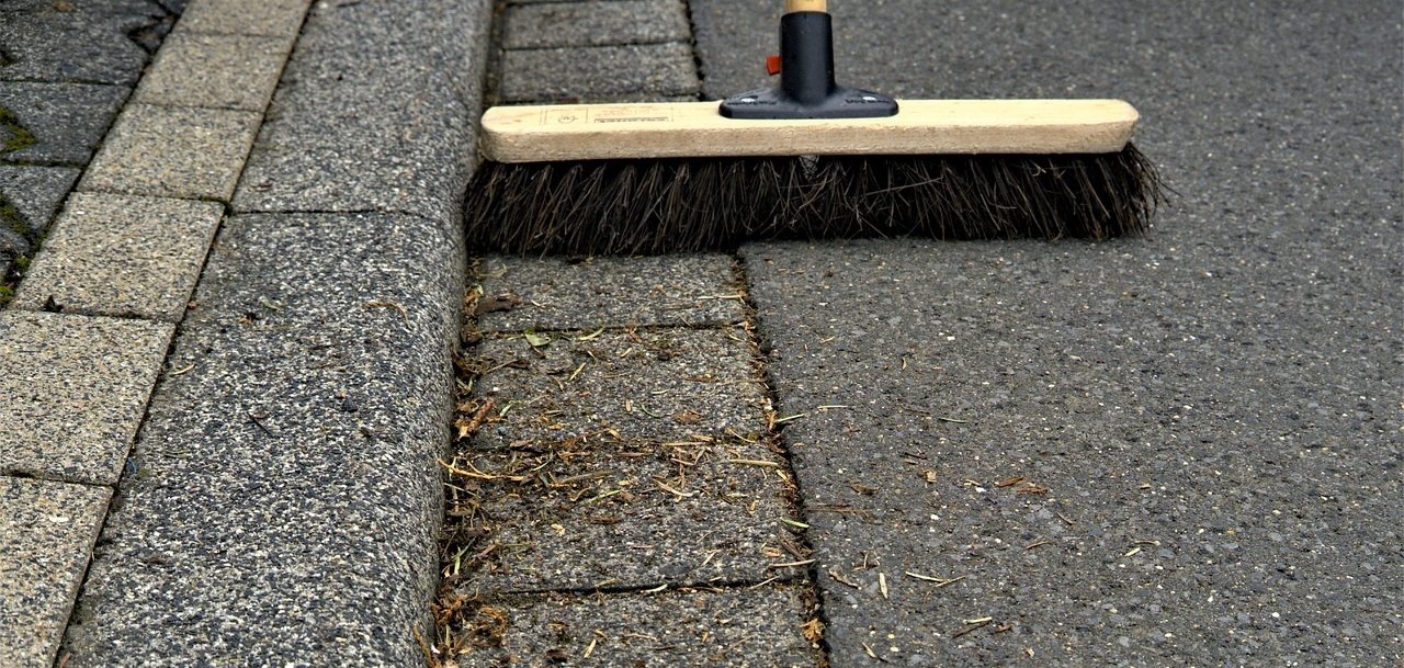 Besen kehrt Bordsteinkante