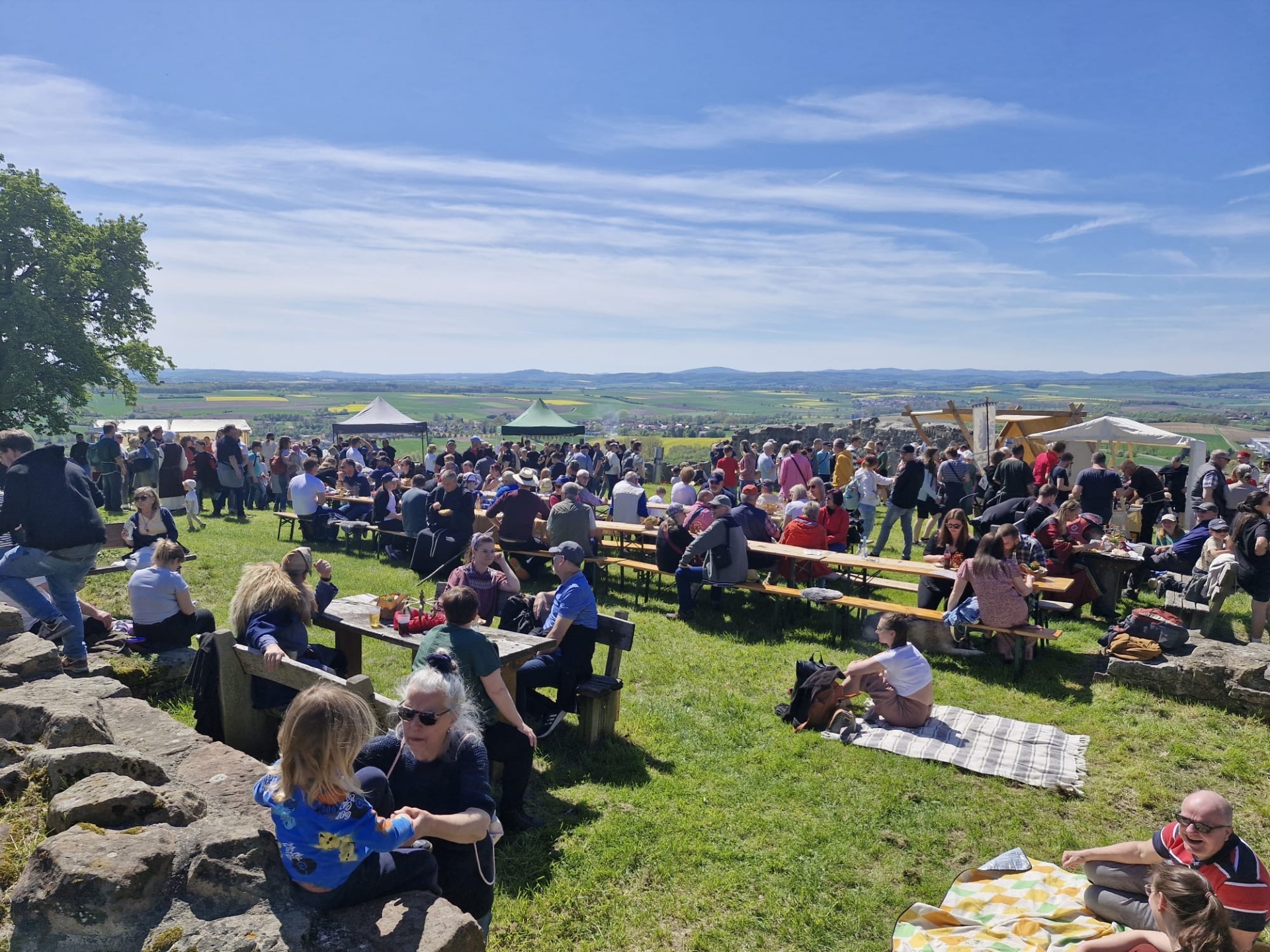 Menschen sitzen auf Veranstaltungsfläche beim Obernburgfest.